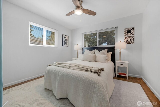 bedroom with a ceiling fan, baseboards, and wood finished floors