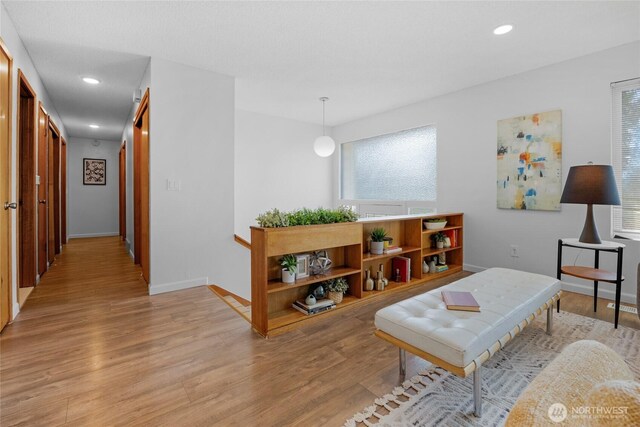 living room with recessed lighting, baseboards, and light wood-style floors