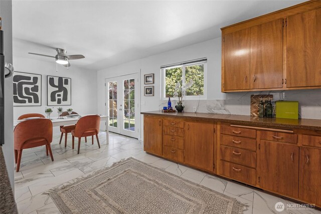 kitchen featuring french doors, brown cabinetry, and marble finish floor