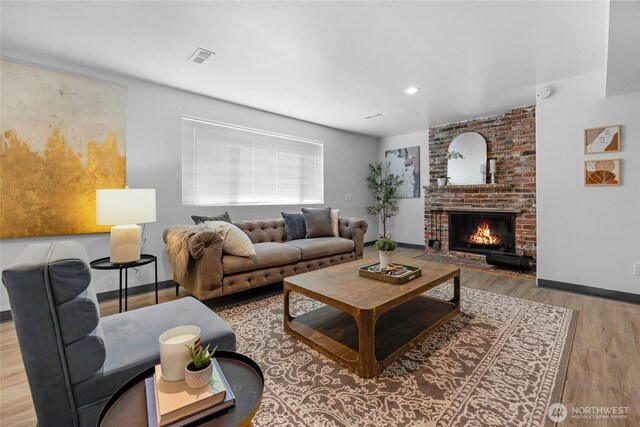 living room with baseboards, recessed lighting, wood finished floors, and a fireplace