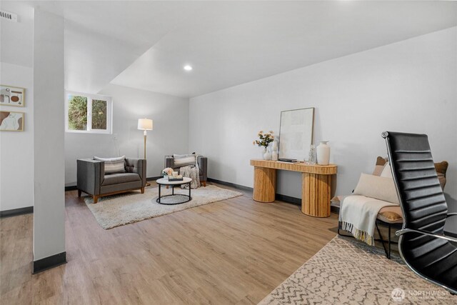 living room featuring baseboards, recessed lighting, and wood finished floors