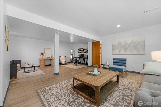 living room featuring light wood-style floors, baseboards, recessed lighting, and visible vents