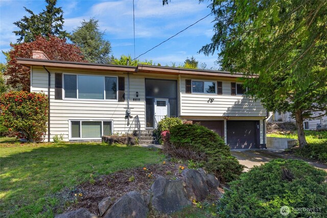 bi-level home with a chimney, a front yard, and a garage