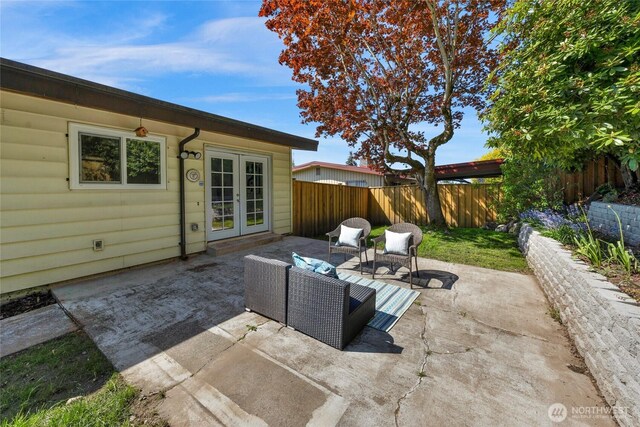 view of patio with french doors, an outdoor living space, and a fenced backyard