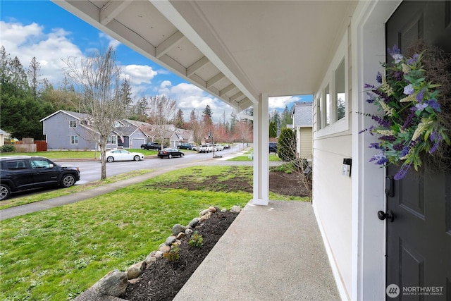 view of yard with a residential view and covered porch