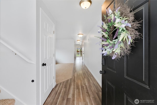 foyer featuring baseboards and wood finished floors