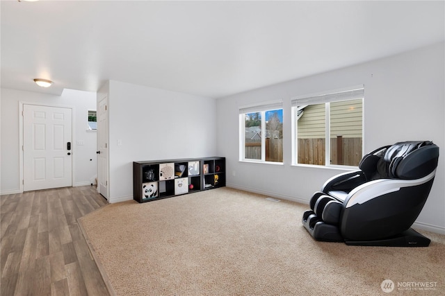 sitting room featuring baseboards, visible vents, and wood finished floors