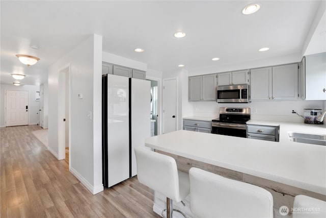 kitchen featuring gray cabinetry, a sink, and stainless steel appliances