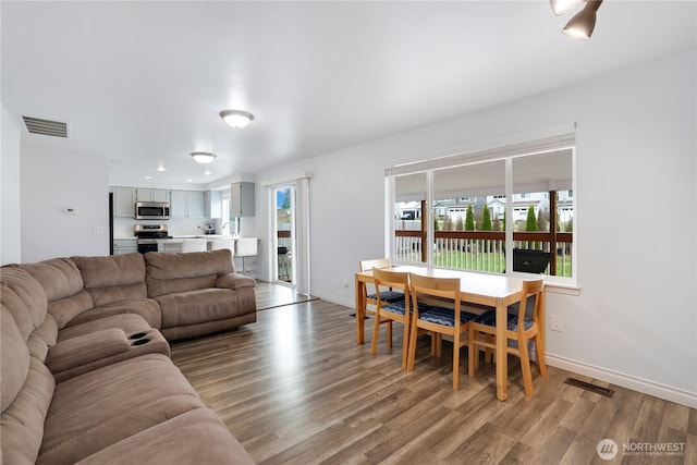 living room with visible vents, wood finished floors, and plenty of natural light