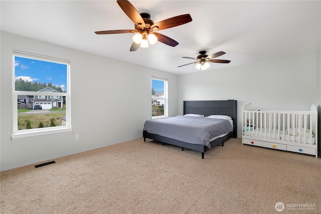 bedroom featuring carpet floors, baseboards, ceiling fan, and visible vents