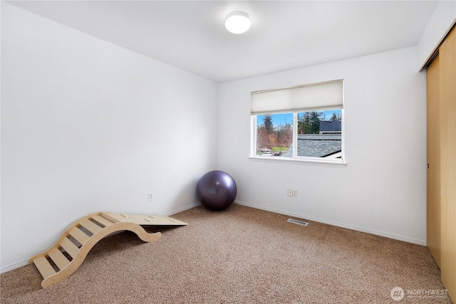 workout room featuring baseboards, visible vents, and carpet