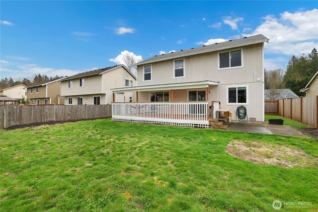 rear view of property with a fenced backyard, a patio area, a deck, and a lawn