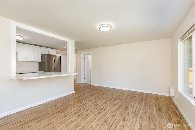 3513 NE 7th Pl, Renton, WA 98056 - unfurnished living room with light wood-style floors and baseboards