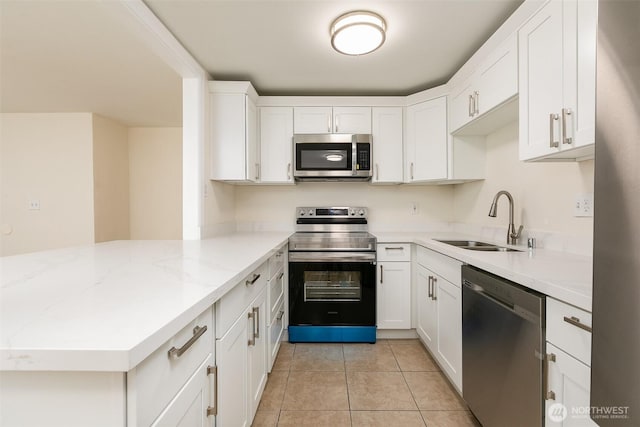 3513 NE 7th Pl, Renton, WA 98056 - kitchen with a peninsula, white cabinetry, light tile patterned flooring, stainless steel appliances, and a sink