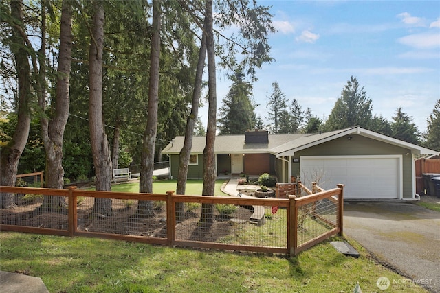 single story home with driveway, a chimney, fence, an attached garage, and a front lawn