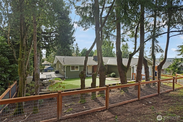 rear view of property with a fenced backyard, a lawn, and roof with shingles