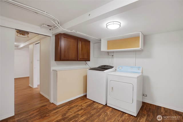 clothes washing area featuring baseboards, washing machine and dryer, and wood finished floors