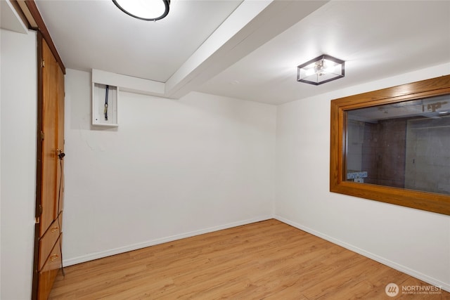 spare room with baseboards and light wood finished floors