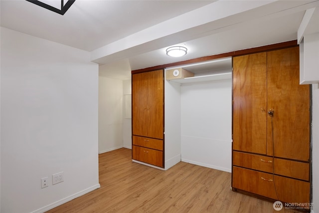 unfurnished bedroom featuring baseboards and light wood-type flooring