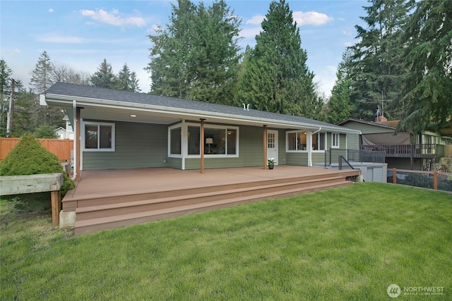 back of house featuring a deck, fence, and a yard