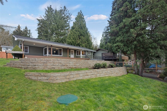 rear view of house with a lawn and fence