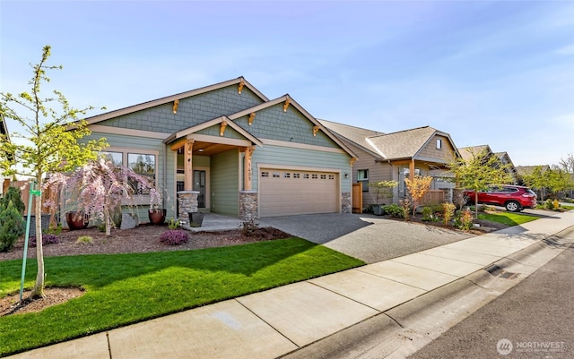 craftsman inspired home featuring concrete driveway, stone siding, an attached garage, a front yard, and fence