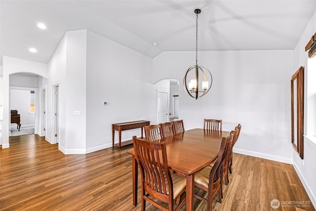 dining space with arched walkways, lofted ceiling, and wood finished floors