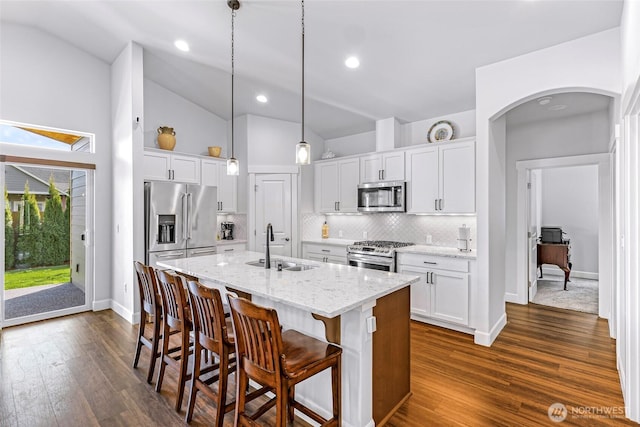 kitchen with a sink, appliances with stainless steel finishes, a breakfast bar, and white cabinetry