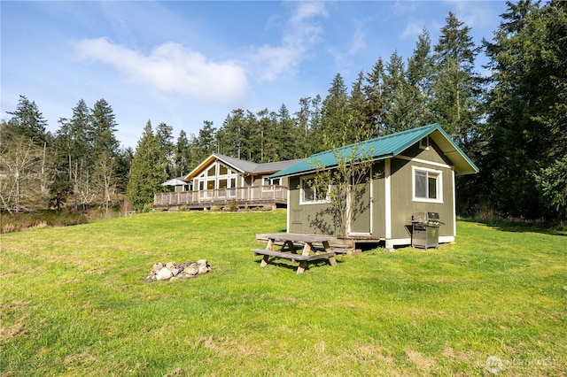 324 Gill Ln, Friday Harbor, WA 98250 - back of house featuring an outdoor structure, metal roof, a lawn, and a wooden deck