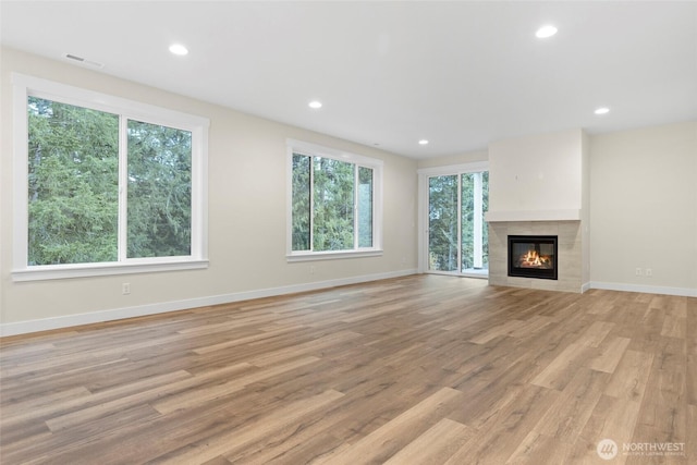 19457 116th St E, Bonney Lake, WA 98391 - unfurnished living room with light wood-style flooring, baseboards, a tiled fireplace, and recessed lighting