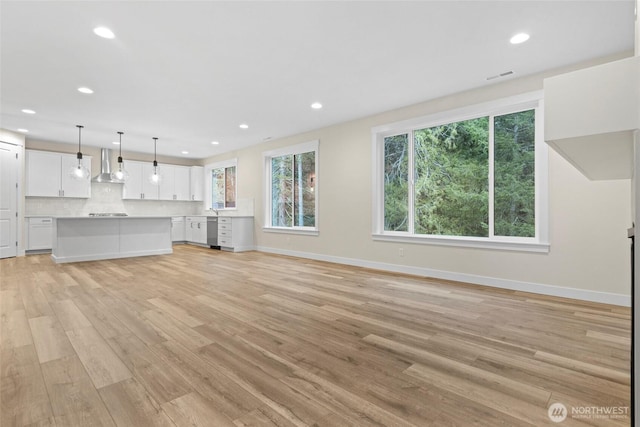 19457 116th St E, Bonney Lake, WA 98391 - unfurnished living room with light wood finished floors, recessed lighting, and baseboards