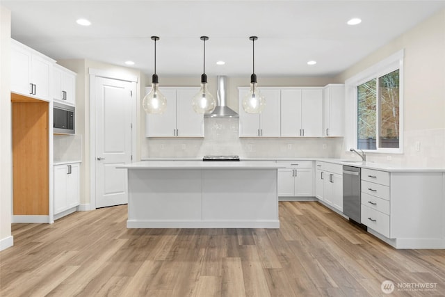 19457 116th St E, Bonney Lake, WA 98391 - kitchen with wall chimney exhaust hood, appliances with stainless steel finishes, decorative backsplash, white cabinets, and light wood-style flooring