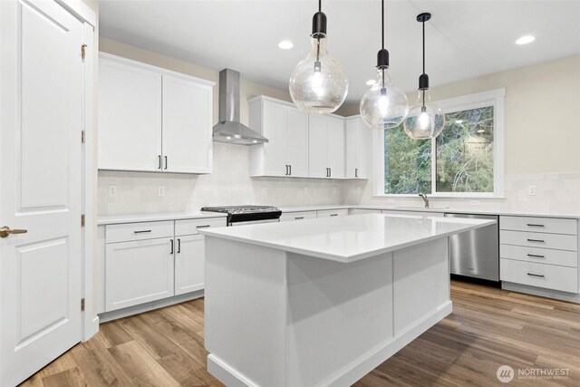 19457 116th St E, Bonney Lake, WA 98391 - kitchen with wall chimney range hood, appliances with stainless steel finishes, a sink, light wood-type flooring, and backsplash