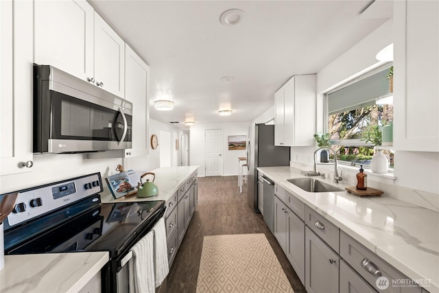 14207 6th Ave S, Burien, WA 98168 - kitchen with a sink, appliances with stainless steel finishes, dark wood-style floors, white cabinetry, and light stone counters