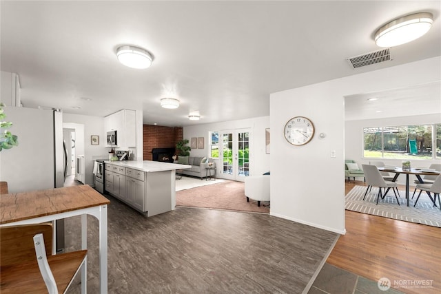 14207 6th Ave S, Burien, WA 98168 - kitchen featuring open floor plan, light countertops, visible vents, stainless steel appliances, and wood finished floors