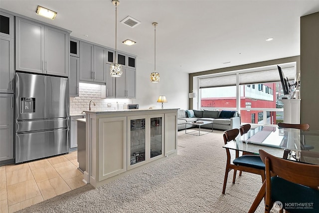 708 Market St Unit 711, Tacoma, WA 98402 - kitchen with tasteful backsplash, gray cabinetry, glass insert cabinets, stainless steel refrigerator with ice dispenser, and visible vents
