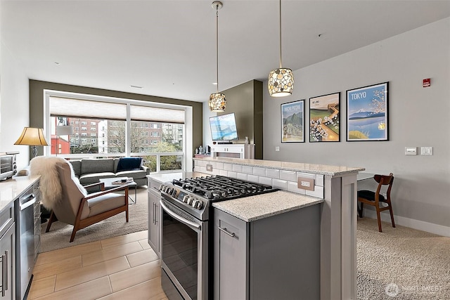 708 Market St Unit 711, Tacoma, WA 98402 - kitchen featuring light stone countertops, appliances with stainless steel finishes, open floor plan, gray cabinets, and a center island