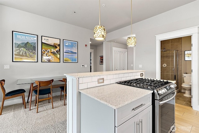 708 Market St Unit 711, Tacoma, WA 98402 - kitchen featuring a kitchen island, decorative light fixtures, light stone countertops, and gas stove
