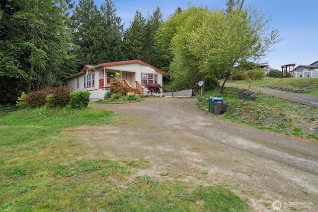 view of front of house with a porch and dirt driveway