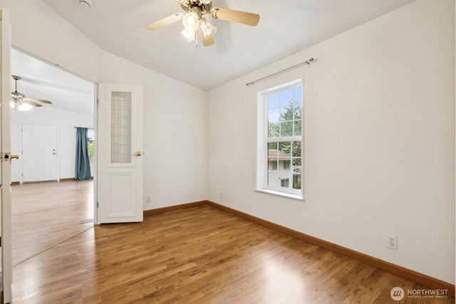 unfurnished room with a ceiling fan, baseboards, wood finished floors, and lofted ceiling