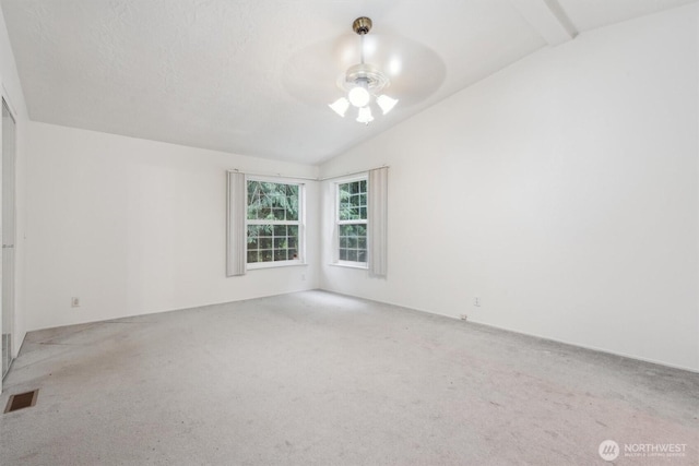 carpeted empty room with visible vents, ceiling fan, and lofted ceiling