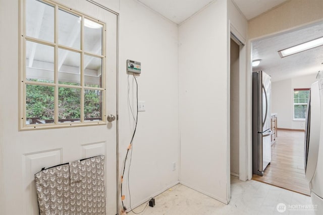 interior space with baseboards and light floors