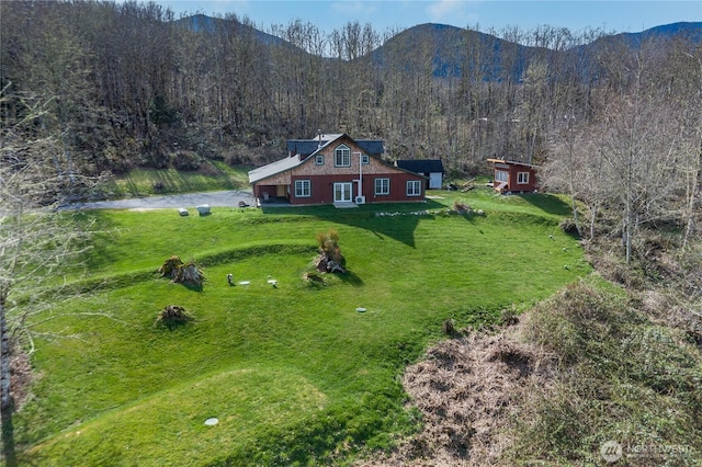 drone / aerial view featuring a forest view and a mountain view