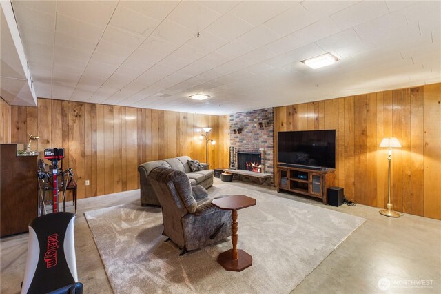 living area with a fireplace, wood walls, and concrete floors