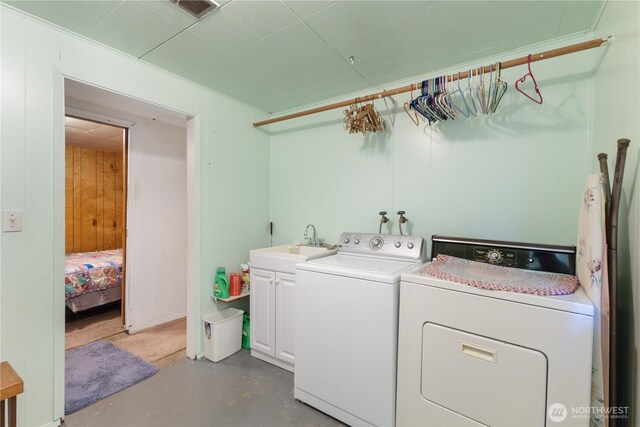 laundry area featuring a sink, visible vents, cabinet space, and washer and clothes dryer