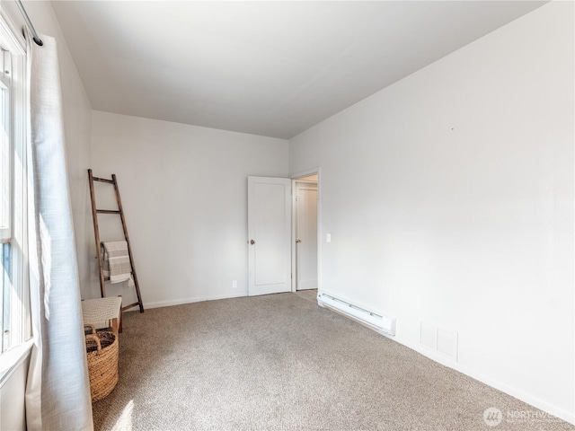 unfurnished room featuring carpet floors, baseboards, visible vents, and a baseboard heating unit