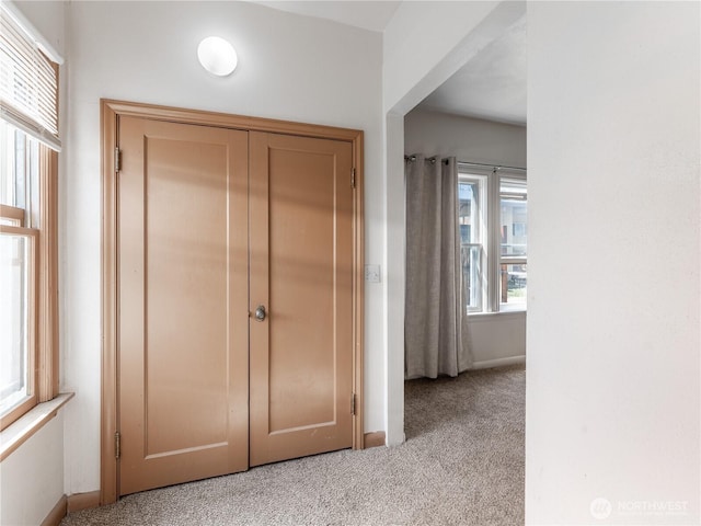 hall featuring baseboards and carpet floors