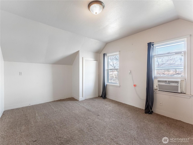 additional living space with cooling unit, carpet floors, baseboards, and vaulted ceiling
