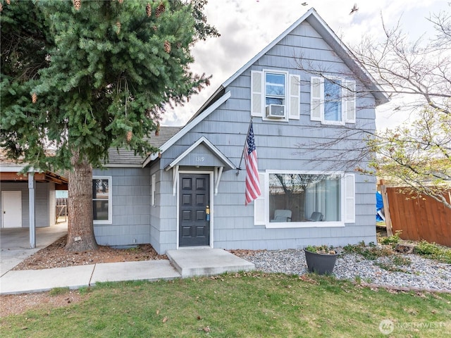 view of front of house with an attached carport, fence, and a front lawn
