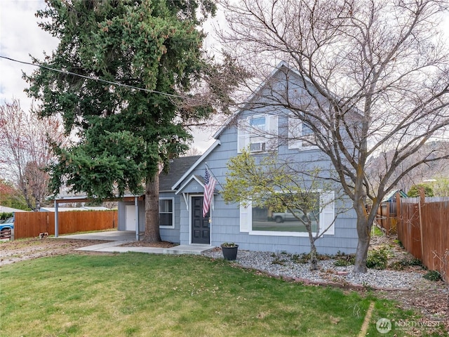 view of front facade with fence, roof with shingles, and a front yard
